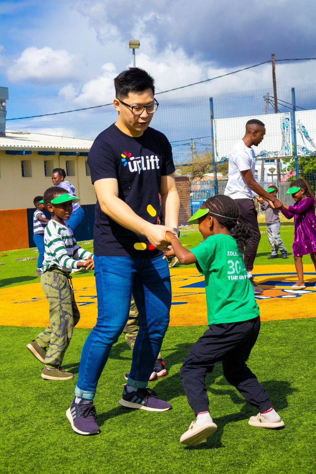 A volunteer playing soccer with children on a field