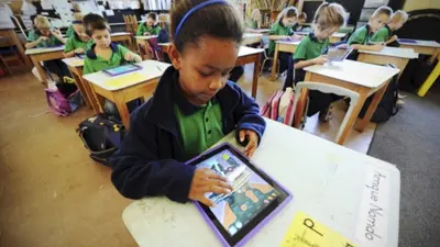 A child using a tablet at a classroom desk